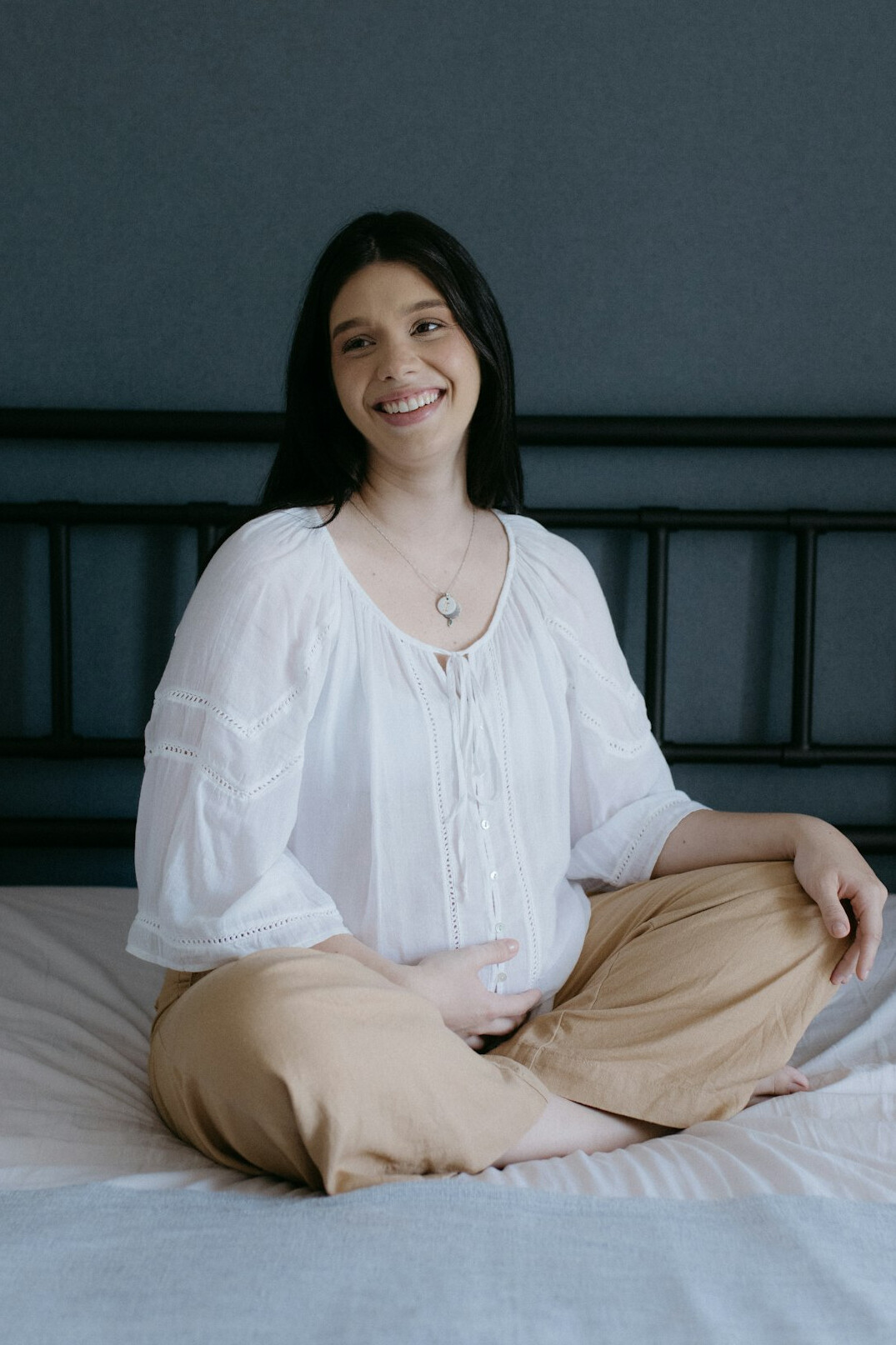Portrait of a smiling Latina woman in her 30s with dark hair wearing a light blouse